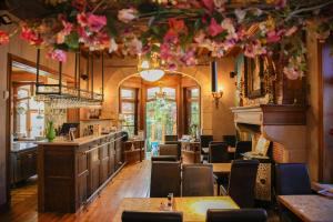 a restaurant with tables and chairs and flowers hanging from the ceiling at Thermae Grimbergen Hotel in Grimbergen