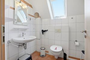 a white bathroom with a sink and a toilet at Möwenblick in Norddeich +31 photos