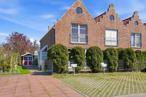 a red brick house with bushes in front of it at Möwenblick in Norddeich