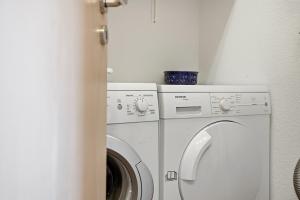 a laundry room with a washing machine and a washer at Möwenblick in Norddeich