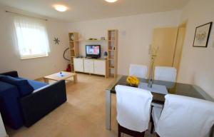 a living room with a table and white chairs at Apartments Ravlic in Punat