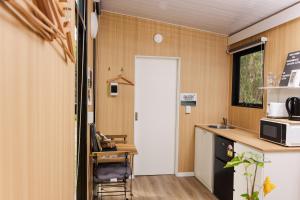 a kitchen with a door and a table and a counter at Bushwalk Escape 1770 in Agnes Water
