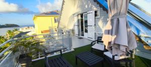 a balcony of a house with chairs and an umbrella at APPARTEMENT SANS SOUCIS in Le Vauclin +3 photos