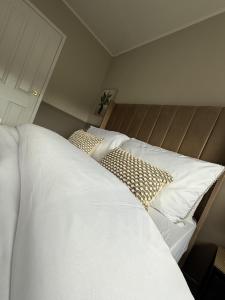 a bedroom with two beds with white sheets and pillows at Knowes Apartment in Duntocher +7 photos