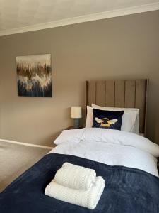 a bedroom with a bed with two towels on it at Knowes Apartment in Duntocher