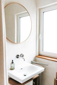a bathroom with a white sink and a mirror at Seetraum Steffi in Zoznegg