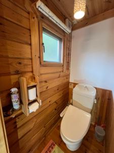 a bathroom with a white toilet and a window at Family Cottage Pokhara in Yamanakako