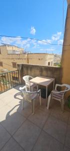 a patio with a table and chairs on a balcony at Quiet, spacious 3 bedroom 2 bathroom apartment in Għajnsielem