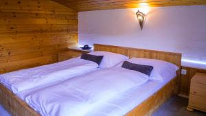 a bedroom with a large bed with white sheets at Alpenresorts in Jerzens