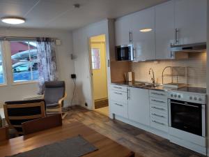 a kitchen with white cabinets and a dining room at Tärnaby Sportstugor in Tärnaby