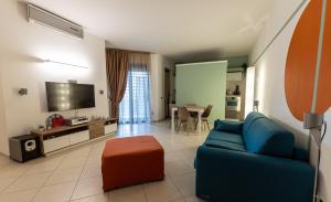 a living room with a blue couch and a tv at Il Bergamotto in Bitritto
