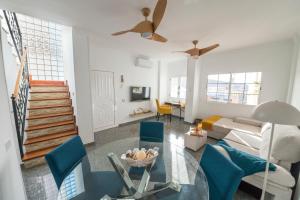 a living room with a glass table and blue chairs at Sea Breeze Arguineguin in Mogán