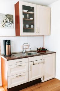 a kitchen with white cabinets and a sink at Seetraum Steffi in Zoznegg