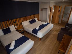 ein Hotelzimmer mit zwei Betten und einer Couch in der Unterkunft Hotel Bríos in Lugo + 21 Fotos