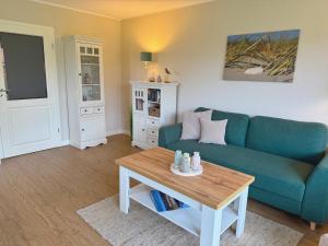 a living room with a blue couch and a coffee table at Wohnung Wiesenblick Whg 1 in Böhl +3 photos