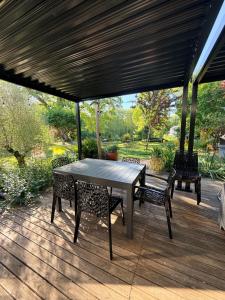 a patio with a table and chairs on a deck at Villa du Beau Port in Cenon-sur-Vienne