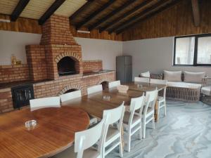 a room with a table and chairs and a fireplace at Pensiunea Floro in Întorsura Buzăului