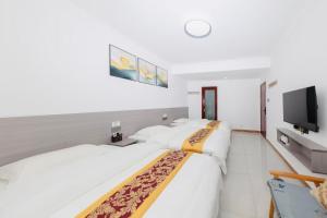 a bedroom with two beds and a flat screen tv at Sky Gate Guesthouse-English Speaking Hostess, Family friendly,2-minute walk to Entrance of Tianmen Mount ,Free pick up service,Book attraction tickets, Free Laundry,Private Tour in Zhangjiajie