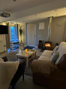 a living room with a couch and a table and a fireplace at Hot tub Retreat, Linlithgow in Linlithgow