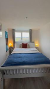 a bedroom with a large white bed with a window at Hot tub Retreat, Linlithgow in Linlithgow