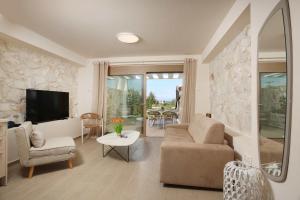 a living room with a couch and a tv at Aquaris in Hanioti