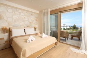 a bedroom with a large bed and a balcony at Aquaris in Hanioti +71 photos