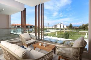 a living room with a balcony with chairs and a table at Aquaris in Hanioti