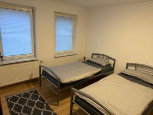 two twin beds in a room with two windows at Guest House Harmony in Lutherstadt Eisleben +15 photos