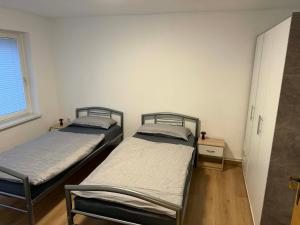 two twin beds in a room with a window at Guest House Harmony in Lutherstadt Eisleben