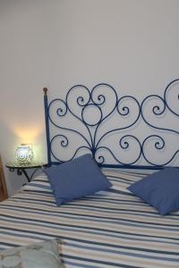 a bedroom with a bed with a blue and black headboard at La carezza dell'Elba in Poggio +18 photos