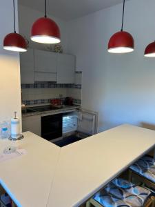 a kitchen with a white counter and red lights at La carezza dell'Elba in Poggio