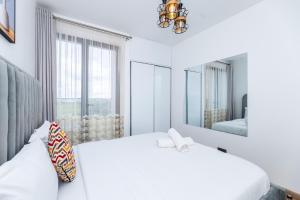a white bedroom with two beds and a mirror at Snyder luxe homes 1 in Tatu City