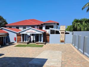 a house with a white fence and a brick driveway at San D- Lux Boutique Hotel in Durban