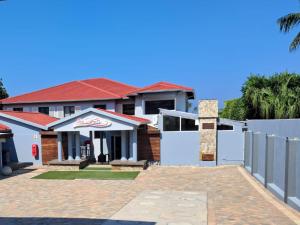 a house with a white gate and a fence at San D- Lux Boutique Hotel in Durban