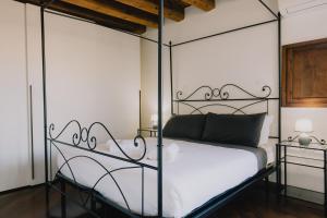 a bedroom with a metal canopy bed with white sheets at Cavour Luxury Apartments in Verona