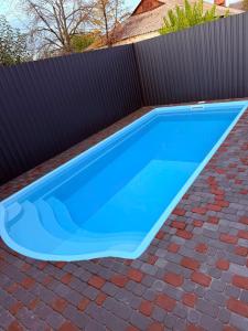 a blue swimming pool on top of a brick yard at Сучасні квартири електроенергія, тепло і гаряча вода є ЗАВЖДИ in Poltava