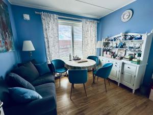 a blue living room with a table and chairs at Beach & City Fun plus Elevator & Free Parking in Hellerup