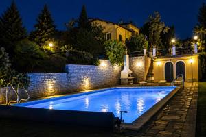 a swimming pool in a backyard at night at Villa Romilda in Arona