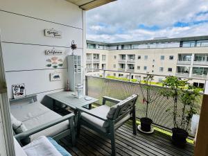 a balcony with a table and a bench on a building at Beach & City Fun plus Elevator & Free Parking in Hellerup