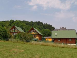 a group of houses in a field with a fence at Der Fuchsbau - 3 Blockhäuser in Bad Sachsa