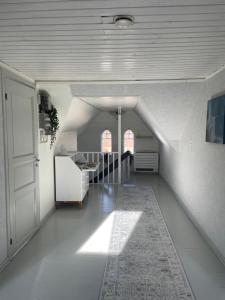 a hallway with a staircase in a white room at Huset på hörnet in Hammenhög