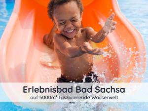 a young child on an inflatable raft in the water at Der Fuchsbau - 3 Blockhäuser in Bad Sachsa