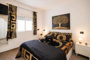 a bedroom with a bed with a tree painting on the wall at Apartamento Alba Lanzarote in Puerto del Carmen