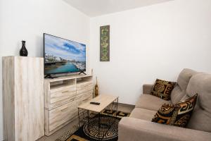 a living room with a couch and a flat screen tv at Apartamento Alba Lanzarote in Puerto del Carmen