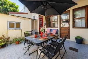 a black table with chairs and an umbrella on a patio at Patio House - 2 Bedroom flat in Porto