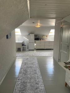 a white kitchen with a refrigerator and a table at Huset på hörnet in Hammenhög