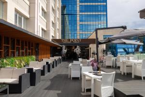 a restaurant with white tables and chairs in front of a building at Hotel Сomplex Irtysh in Pavlodar