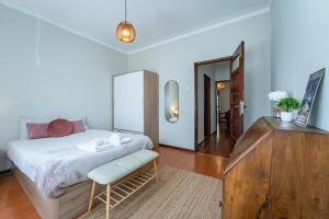 a bedroom with a bed and a dresser and a mirror at Patio House - 2 Bedroom flat in Porto