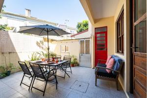 a patio with a table and chairs and an umbrella at Patio House - 2 Bedroom flat in Porto
