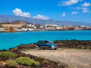 a blue van parked next to a body of water at Tenerife Camper Van Teide Surf and Beaches Sleeps 2 in San Miguel de Abona